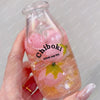 A hand holds a clear glass bottle filled with pink squishy stress balls labeled Chiboki