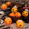 A collection of orange pumpkin and white skeleton sensory stress balls displayed on a wooden box and parchment paper.