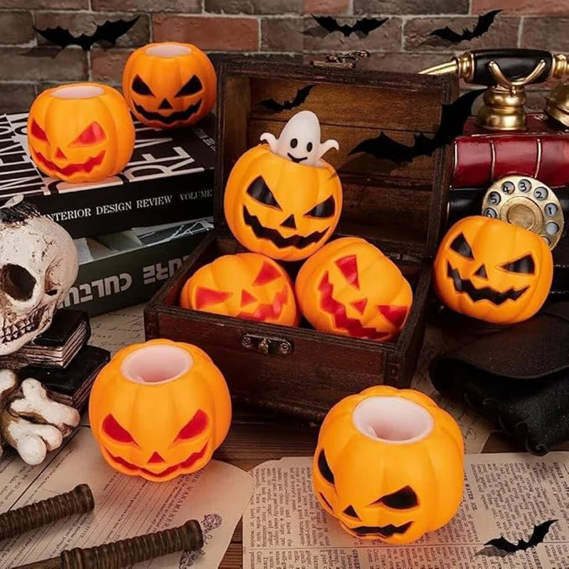 A collection of orange pumpkin and white skeleton sensory stress balls displayed on a wooden box and parchment paper.