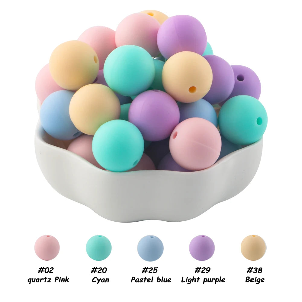 A bowl filled with assorted silicone beads in various pastel and earth tones including pink, cyan, blue, purple, and beige.