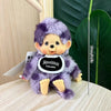 A purple fluffy cartoon plush character with large eyes and a black collar is displayed next to a measuring scale.