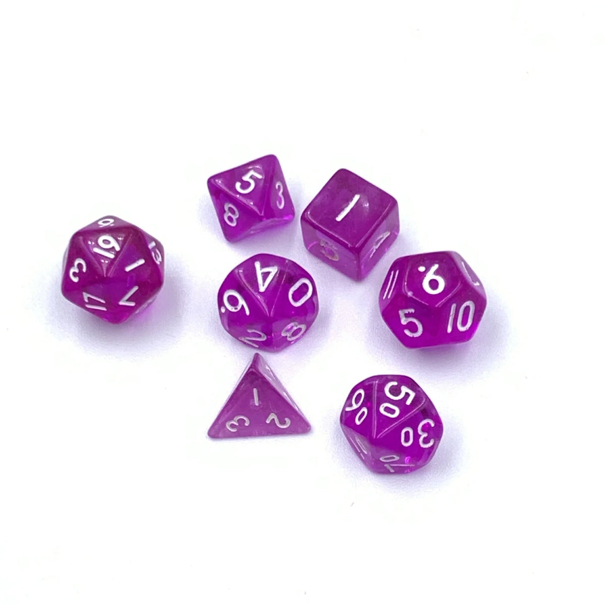 A set of seven transparent purple acrylic dice, including d6 and d10 shapes, scattered on a white surface.