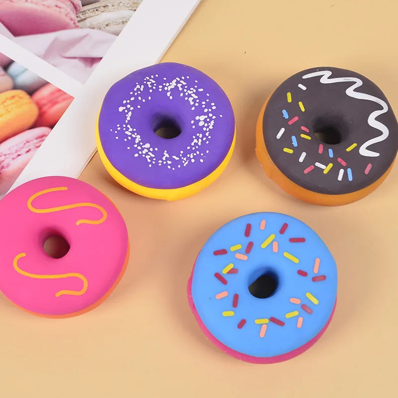 A collection of colorful, glazed donuts with sprinkles, including purple, black, and blue varieties.