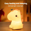 A cute unicorn silicone LED night light emitting a soft, warm glow on a wooden surface.