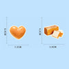 A heart-shaped piece of orange food-themed sticker, next to a rectangular piece of yellow food-themed sticker.