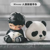 A collectible figure of a black-haired character next to a white panda figure.