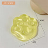 A yellow squishy toy shaped like a cat paw, featuring multiple soft jelly pads and glitter accents.