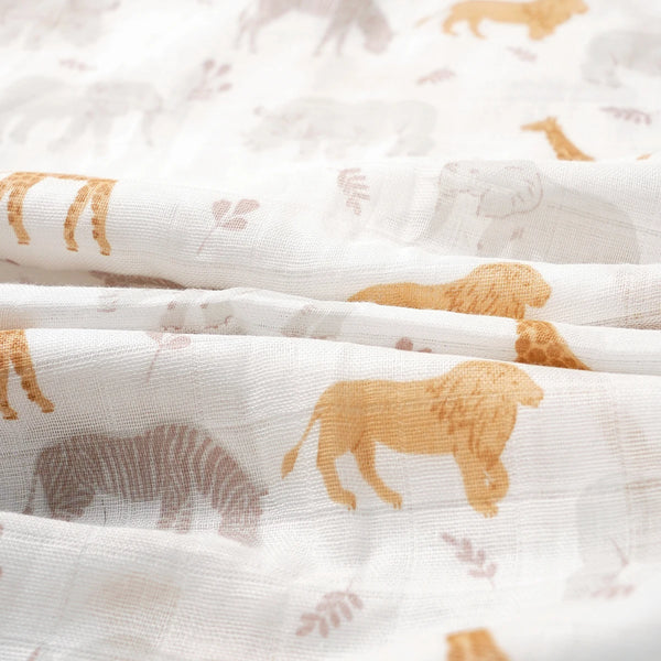 A close-up of a white fabric featuring a pattern of golden and gray animal silhouettes on a textile surface.