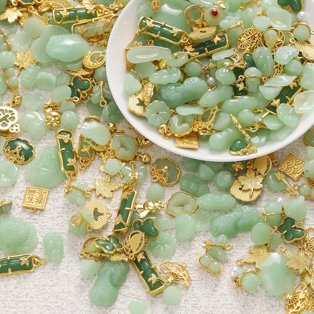 A pile of light green imitation jade charms and gold-colored jewelry components for crafting.