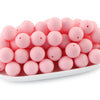 A pile of round, pink silicone beads for jewelry making and DIY crafts.