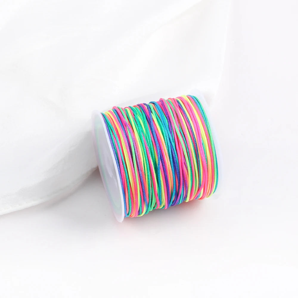 A roll of multicolored macrame cord in various shades of green, pink, and yellow for jewelry making.