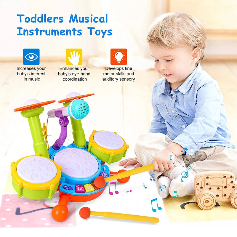 A toddler plays with an interactive drum set featuring light-up pads, a microphone, and various colorful wooden instruments.
