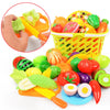 A colorful pretend play kitchen set featuring plastic fruit and vegetable cutting tools and food items.