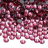 A close-up view of small, faceted glass crystal rhinestones in various shades of pink and red.