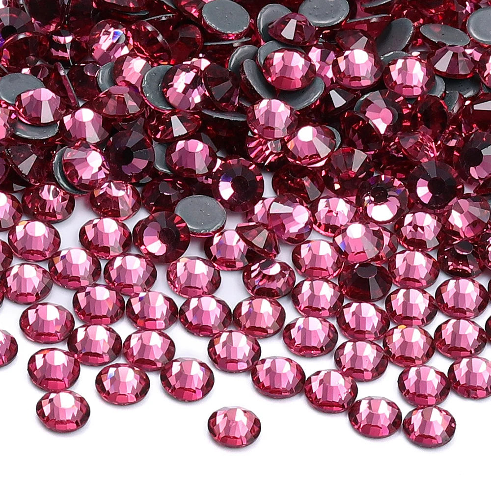 A close-up view of small, faceted glass crystal rhinestones in various shades of pink and red.
