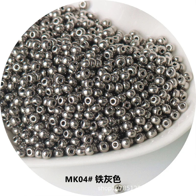 A pile of small, silver-colored electroplated metallic glass beads for jewelry and crafting.
