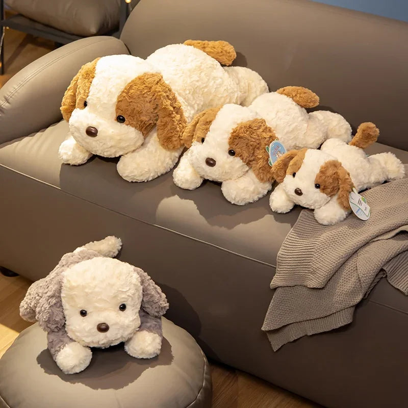 Several adorable lying dog plush toys in white and brown colors are displayed on a beige sofa.