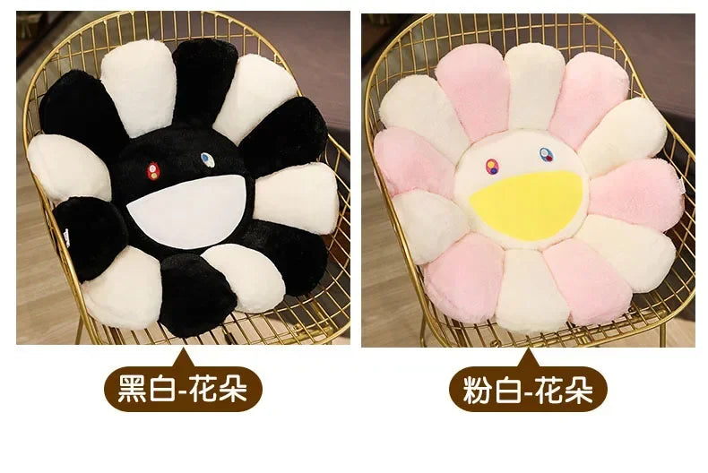 Two plush sunflower cushions, one black and white, and one pink and white, displayed on a gold wire tray.
