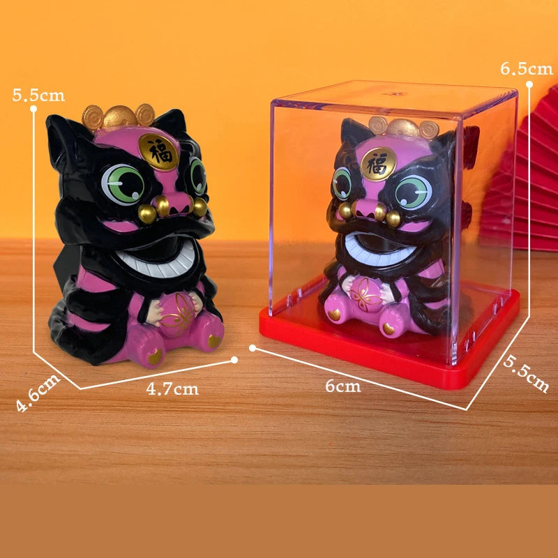 A small, dark purple cat figurine with gold accents is displayed inside a clear box on a red base.