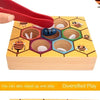 A hand is placing a red clip onto a wooden bee trap game featuring various colored hexagonal beads and insect figures.