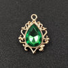 Gold plated water droplet charm featuring a green crystal rhinestone set in an ornate flower design.
