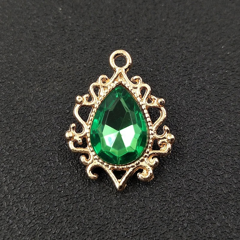 Gold plated water droplet charm featuring a green crystal rhinestone set in an ornate flower design.