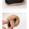 A pair of cozy plush baby slippers with a black anti-slip sole and a light brown fuzzy lining.