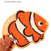 An orange clownfish magnetic puzzle piece with black stripes and white accents being held by a hand.