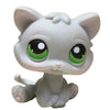 A small, white cat bobble head figurine with large green eyes.