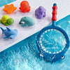 A colorful water-squirting turtle bath toy with a fishing net is shown floating in blue water.