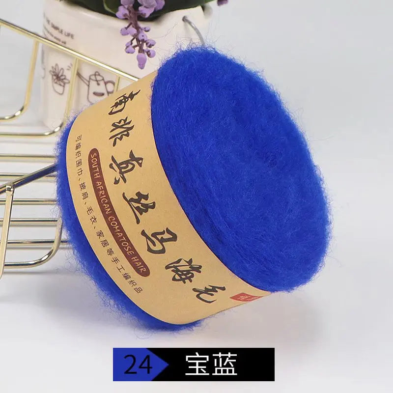 A ball of bright blue silk mohair blended yarn with a tan label is shown on a white background.
