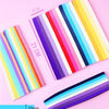 A collection of 27 colorful, striped paper strips laid out on a pink background.