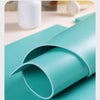 A teal rubber block is shown rolled and partially cut on a light blue surface.