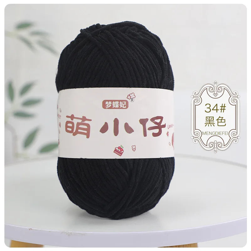 A ball of black chenille yarn labeled with Chinese characters for knitting and crochet.
