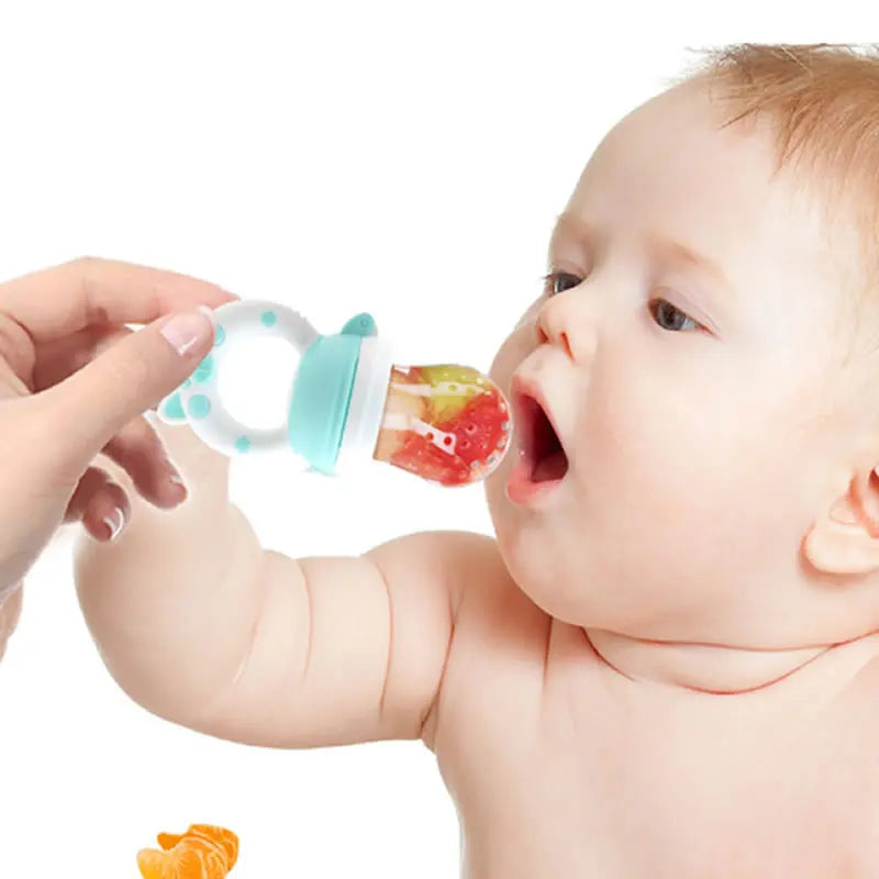 A baby is shown feeding from a silicone baby food feeder with a fruit piece.