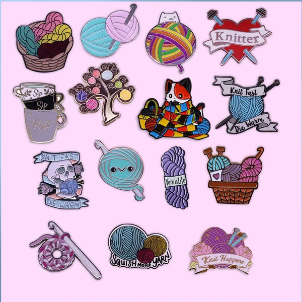A collection of enamel pins and brooches featuring various knit and yarn themed designs.