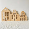 A set of wooden building blocks shaped like houses or buildings for creative play