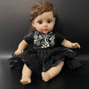 A lifelike 14-inch reborn baby doll with a dark outfit and natural skin tone.