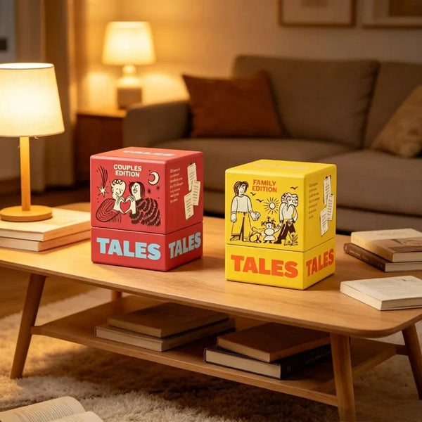 A box set of Tales card game conversation starters in red and yellow packaging resting on a wooden table.