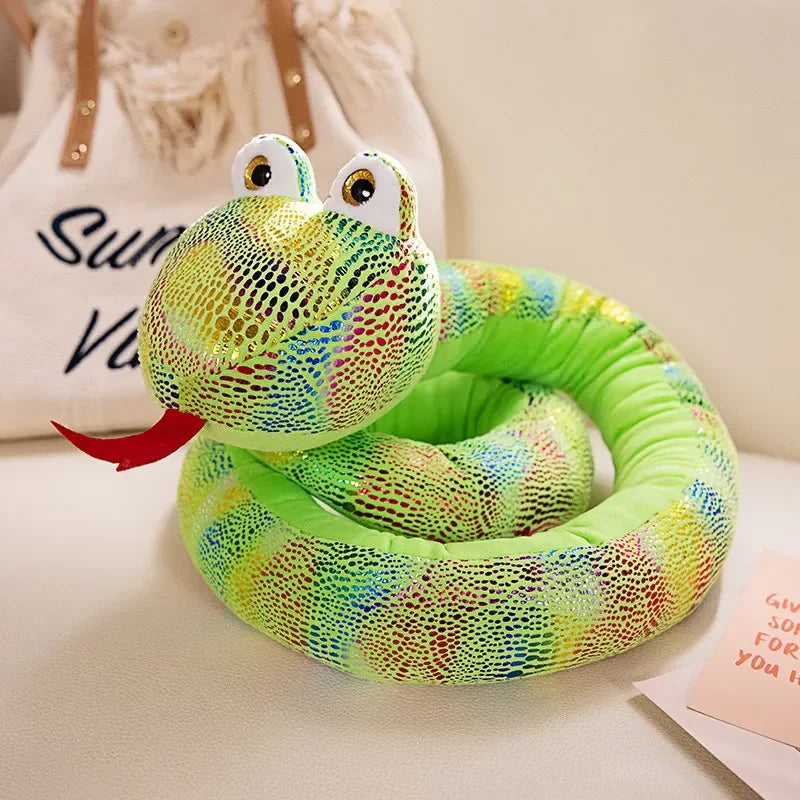 A bright green and yellow cartoon snake plush toy with large eyes is coiled on a white surface.
