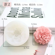 A white silicone mold shaped like a flower, next to a pink, ruffled 3D flower decoration.