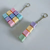 A clear silicone fidget keychain featuring colorful, square tiles in pastel shades of pink, purple, blue, and yellow.