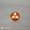 A close-up view of a magnetic LED diorama light with remote control, showing three illuminated orange lights.
