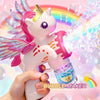 A hand holds a pink unicorn bubble maker emitting colorful light and bubbles.