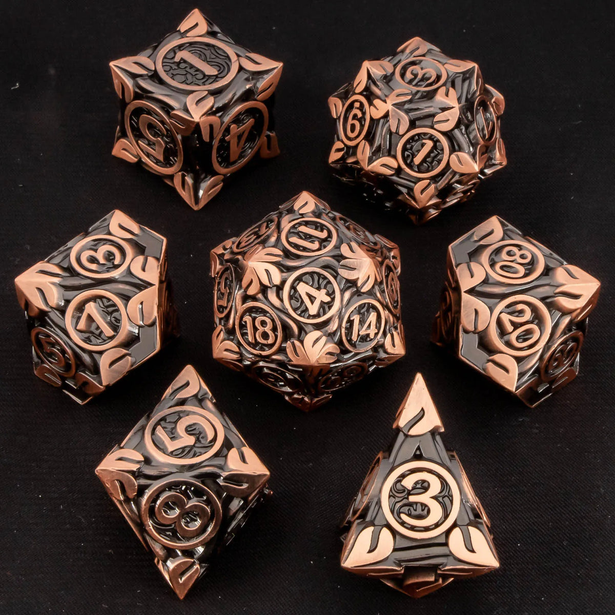 A set of ten premium zinc alloy metal dice in a bronze and black finish arranged on a dark surface.