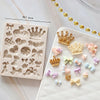 A white silicone cake mold set featuring various baby-themed shapes like crowns, hearts, and bows.