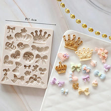 A white silicone cake mold set featuring various baby-themed shapes like crowns, hearts, and bows.