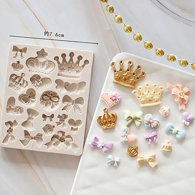 A white silicone cake mold set featuring various baby-themed shapes like crowns, hearts, and bows.
