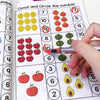 A child's hand is pointing to a preschool math workbook page with numbers and corresponding fruits for tracing and counting.
