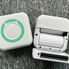 A white pocket thermal printer is shown open, displaying the roll of paper inside, set against a gray fabric background.